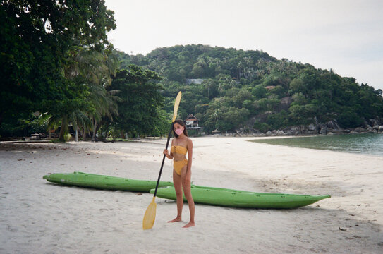 Young woman in bikini standing on sandy beach during covid-19 lockdown