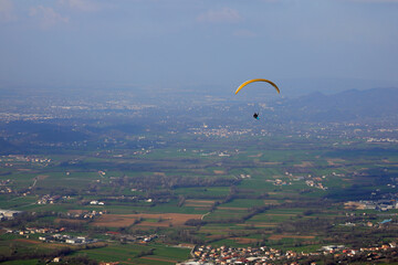 Paragliding during the flight an extreme sport in contact the sky and the houses at the bottom
