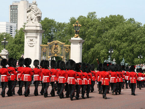 
Royal Guards of the Kings of England parading in front of Buckingham Palace in London. Guards in their red uniforms and bearskins hats marching.