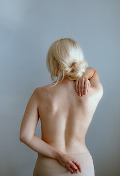 Detail of a woman's naked back with her hands on her back