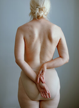 Detail of a woman's naked back with her hands on her back