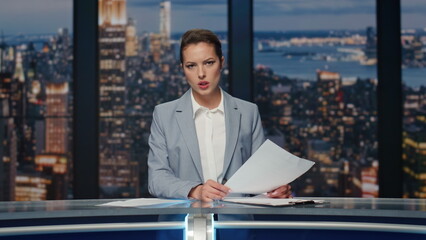 Serious anchorwoman talking news at evening studio closeup. Woman host speaking