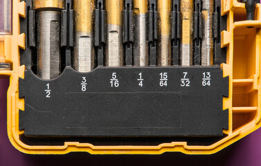 well used imperial sized drill bits in a yellow box holder close up detail macro photo (tools for...