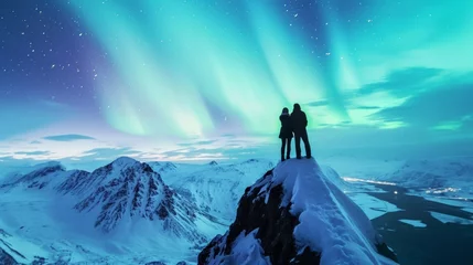 Zelfklevend Fotobehang Two hikers standing on tip of mountain top with majestic view of snow mountain and beautiful aurora northern lights in night sky in winter. © rabbit75_fot