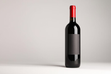 Bottle of tasty red wine on white background, space for text