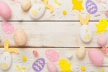 Easter eggs and cute decoration on wooden background, top view