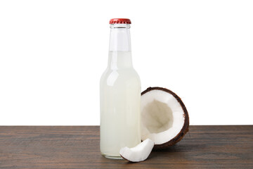 Delicious kombucha in glass bottle and coconut on wooden table against white background