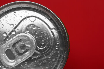Energy drink in wet can on red background, top view. Space for text