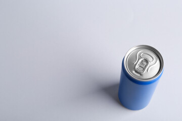 Energy drink in blue can on light grey background, above view. Space for text