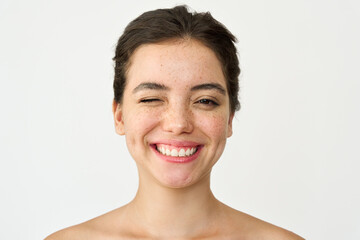 Happy Latin girl, young playful smiling woman model with freckles winking isolated on white...