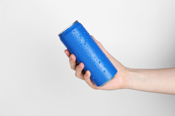 Woman with energy drink on light grey background, closeup