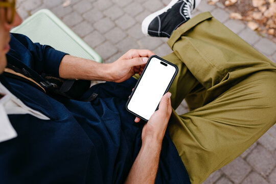 A man uses a mobile phone with a white screen