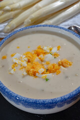 Bowl of homemade cream soup from white asparagus with eggs, spring season, new harvest of Dutch, German white asparagus, cooking with asparagus