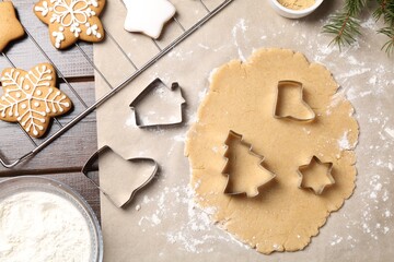 Making Christmas cookies. Flat lay composition with cutters and raw dough on wooden table