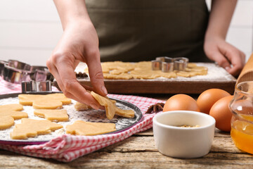 Woman making Christmas cookies at wooden table, closeup