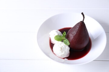 Tasty red wine poached pear with mint and Ice cream on white wooden table, closeup. Space for text