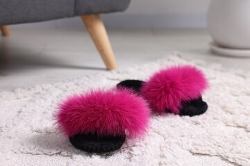 Colorful soft slippers on light carpet, closeup