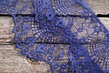 Beautiful lace on wooden table, top view