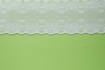 White lace on green background, top view. Space for text