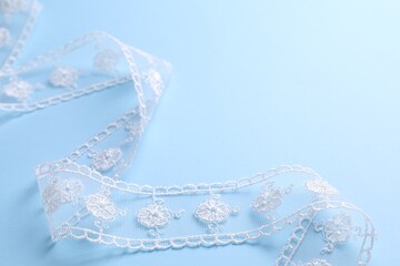 White lace on light blue background, closeup
