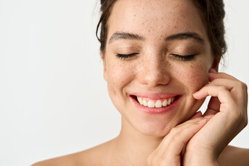 Close up beauty photo of smiling young adult woman with freckles on face enjoying fresh clean...