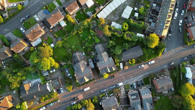 British houses, green gardens and parks from above filmed during golden hour sunset with 4K drone.