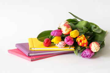 tulips bouquet, flowers with the set of colorful photobooks on the white background