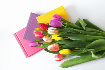 tulips bouquet, flowers with the set of colorful photobooks on the white background