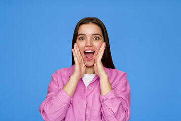 Excited pretty cool gen z surprised Latin customer teenage girl with wow face expression feeling amazed advertising promotion on blue background. Shopping offer surprise concept.