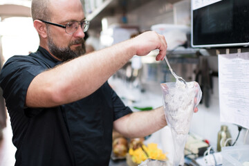 Focused chef preparing pastry bag at kitchen
