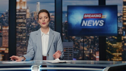 Woman host presenting newscast standing tv stage near screen. Lady breaking news
