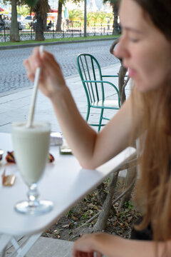 A girl drinks a milkshake on the terrace