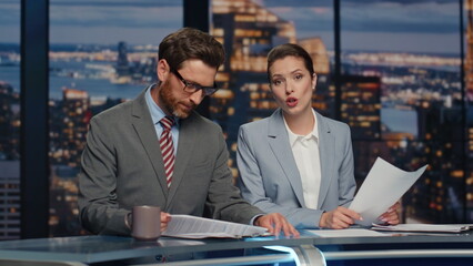 Couple reporters announcing news in late multimedia information channel closeup