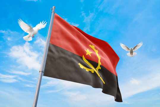 Waving flag of Angola in beautiful sky and flying pigeons. Angola flag for independence day. The symbol of the state on wavy fabric.