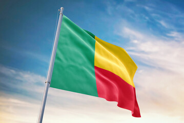 Waving flag of Benin in blue sky. Benin flag for independence day. The symbol of the state on wavy fabric.