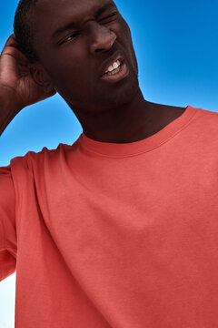 Thoughtful black man touching his head.