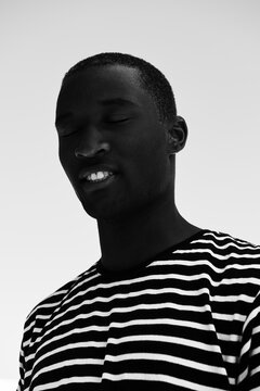 Afro American man laughing with his eyes closed.