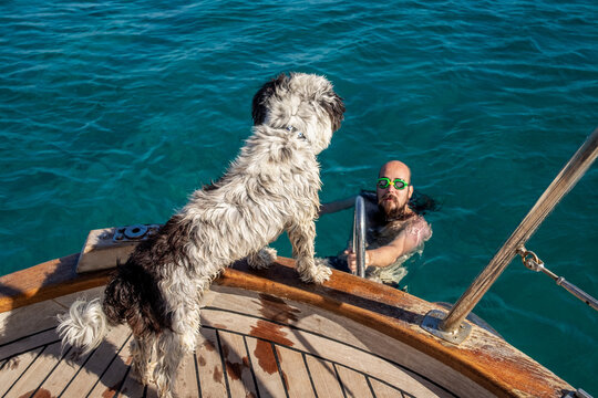 Man with googles coming on a boat after swimming in the sea