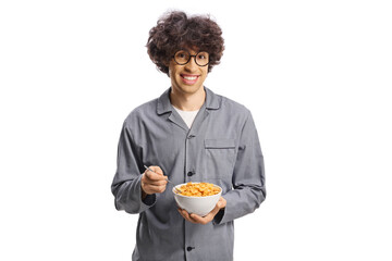 Young man in pajamas holding a bowl of conrflakes