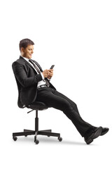 Businessman sitting in an office chair and using a smartphone