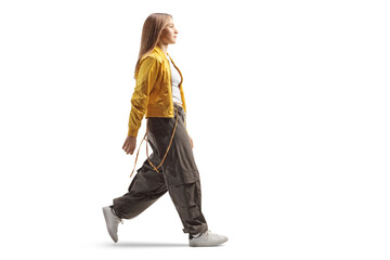 Full length profile shot of a trendy teenage girl walking
