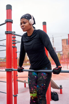 Black fitness model training on parallel bars