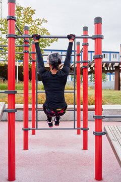 Black female athlete pulls up on parallel bars