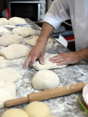 baker kneading dough to make bread