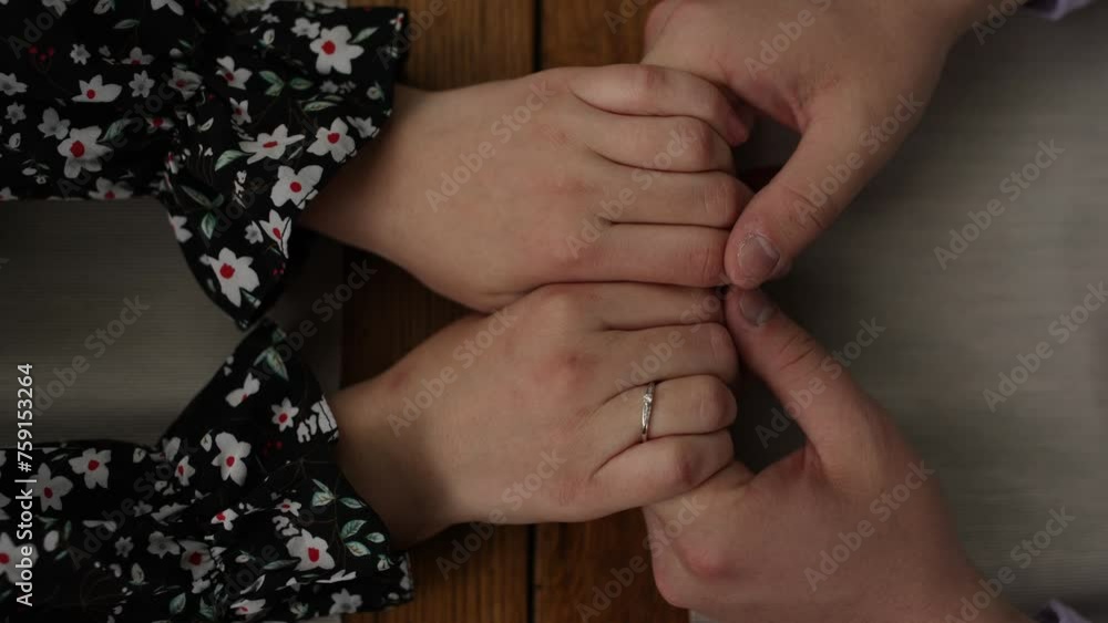 Poster a man holds a woman's hands at a table in a restaurant on a date