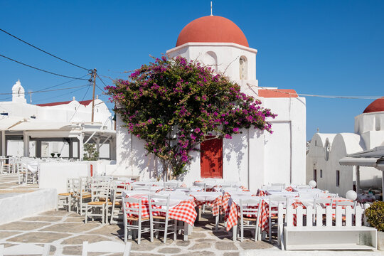 Red dome church and pink flowers at Mykonos, Greek Island 