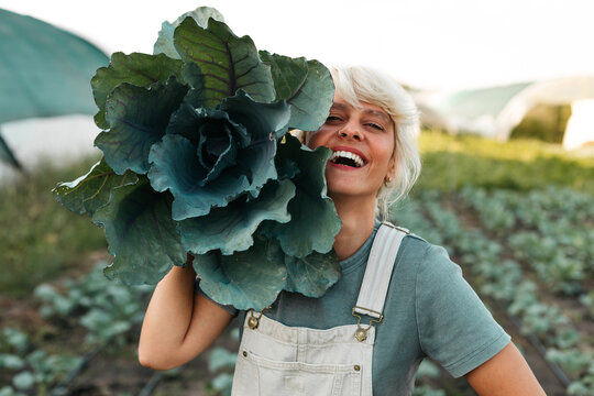 Smiling woman holding a cabbage