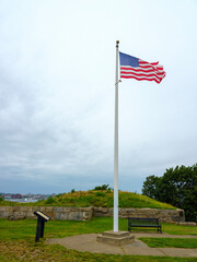 Fototapeta premium American flag waving in the memorial park in Providence, Rhodes Island at Fort Taber Park in New Bedford, Massachusetts, USA
