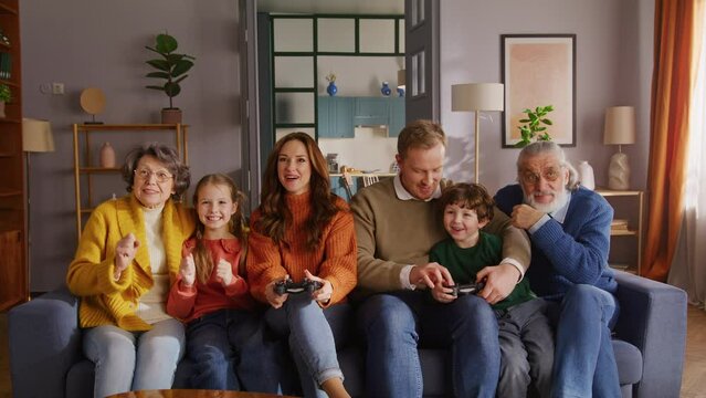 Cheerful family playing online video game with joysticks