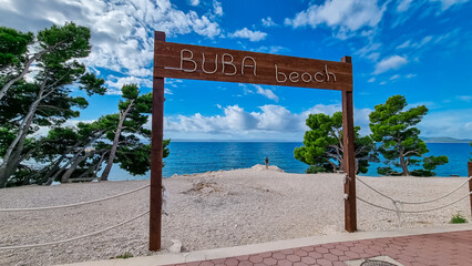 Wooden sign indicating the entrance to idyllic Buba beach along Makarska Riviera, Split-Dalmatia,...